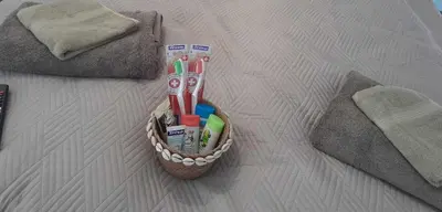 a basket of toothbrushes and toothpaste on a bed at The Central House 2 in Burgas City