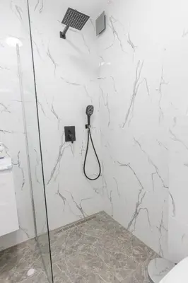 a bathroom with a shower with a phone on the wall at The Central House 2 in Burgas City