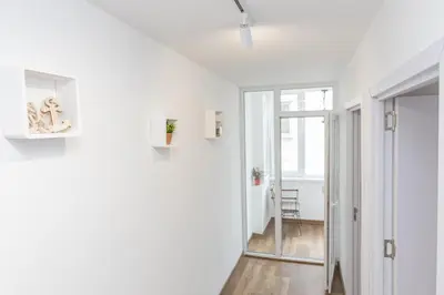 a hallway with white walls and a glass door at The Central House 2 in Burgas City