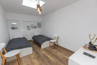 a bedroom with two beds and a table and chairs at The Central House 2 in Burgas City
