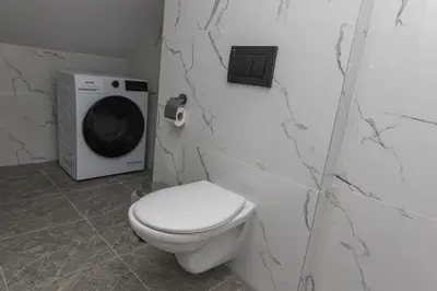 a bathroom with a toilet and a washing machine at The Central House 3 in Burgas City
