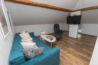 a living room with a blue couch and a chair at The Central House 3 in Burgas City