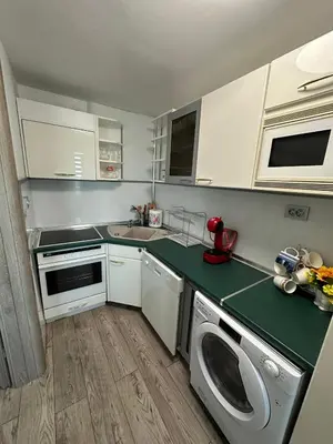 a kitchen with white cabinets and a green counter top at Victoria in Varna City
