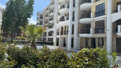 a building with trees in front of it at Tranquilo Escapes in Sunny Beach