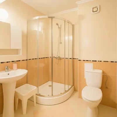 a bathroom with a shower and a toilet and a sink at Helios Seaview Apartment in Sveti Vlas