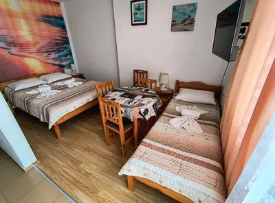 two beds in a room with a table and a tv at Вила Катажина - Villa Katarzyna in Sozopol