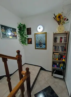 a room with a staircase and a book shelf with books at Вила Катажина - Villa Katarzyna in Sozopol