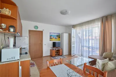 a kitchen and living room with a glass table at Charming 1-Bedroom Apartment in Ravda by Flat Mаnаger in Nesebar
