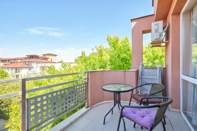 a patio with two chairs and a table on a balcony at Charming 1-Bedroom Apartment in Ravda by Flat Mаnаger in Nesebar