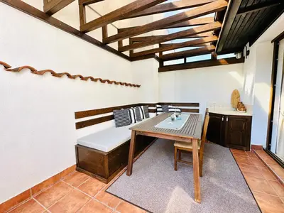 a dining room with a table and a bench at Seaside Oasis Apartment in Lozenets