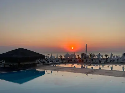 a pool with the sunset in the background at Seaside Oasis Apartment in Lozenets