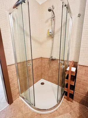 a shower with a glass enclosure in a bathroom at Seaside Oasis Apartment in Lozenets