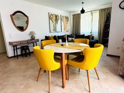 a living room with a table and yellow chairs at Seaside Oasis Apartment in Lozenets