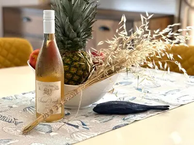 a bottle of wine sitting on a table next to a pineapple at Seaside Oasis Apartment in Lozenets