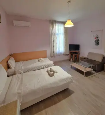 a bedroom with a large bed and a living room at Mateo Center in Varna City