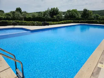 a large blue swimming pool in a yard at Azur properties 7 in Shkorpilovtsi
