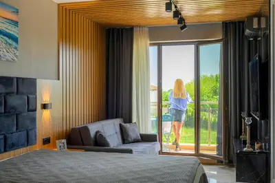 a woman walking out the door of a bedroom at Azur properties 7 in Shkorpilovtsi