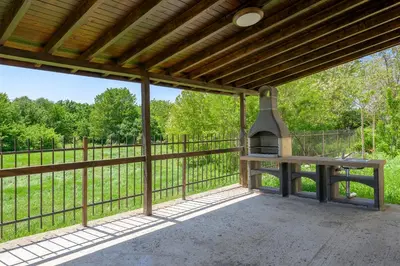 an outdoor patio with a bench and a grill at Azur properties 7 in Shkorpilovtsi