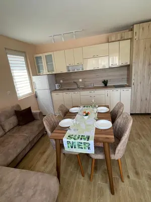a living room with a wooden table and chairs at Garmanovi Apartment in Sozopol, with free parking in Sozopol