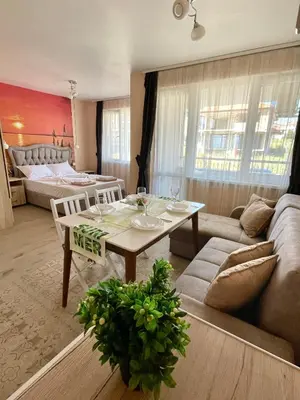 a living room with a table and a couch at Sunset studio in Sozopol, with free parking in Sozopol
