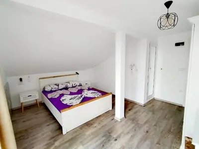 a bedroom with a bed in a white room at Стаи за гости Гергана град Созопол in Sozopol