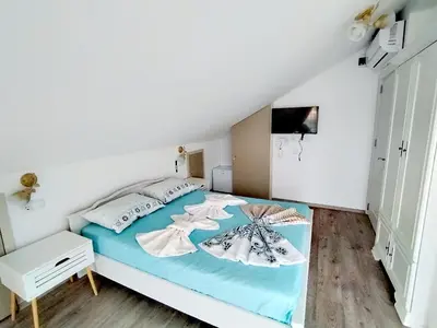 a bedroom with a bed with a blue comforter at Стаи за гости Гергана град Созопол in Sozopol