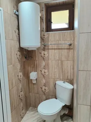 a bathroom with a toilet and a window and a mirror at Стаи за гости Гергана град Созопол in Sozopol