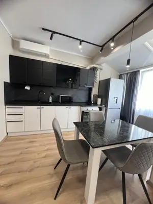 a kitchen with a dining room table and chairs at Varna central apartment with parking for normal to middle sized cars in Varna City