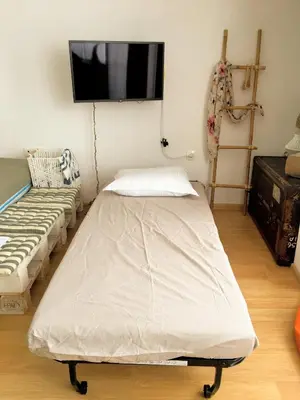 a room with a bed and a tv on a wall at Astell Superior Studio in Burgas City