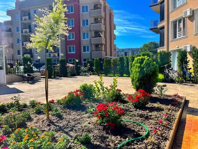 a garden in front of a building with flowers at Апартамент Vip Vision Studio LUX in Sunny Beach