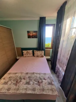 a bedroom with a bed and a window at Апартаменти в Комплекс Трявна Бийч in Sveti Vlas