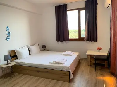 a bedroom with a bed and a window at Отличен Двустаен Апартамент in Primorsko