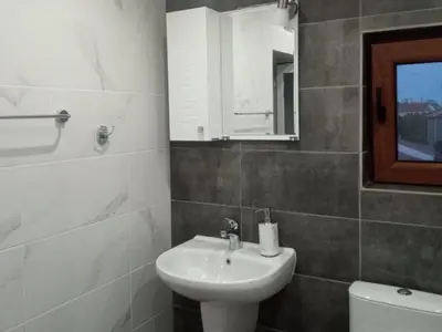a bathroom with a sink and a toilet and a mirror at Vila Mihnevi in Chernomorets