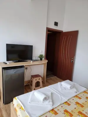 a room with a bed and a desk and a tv at Vila Mihnevi in Chernomorets