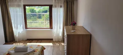 a bedroom with a window and a bed and a dresser at Vila Mihnevi in Chernomorets