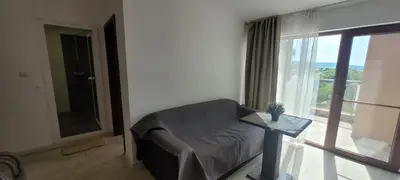 a living room with a couch and a large window at Vila Mihnevi in Chernomorets