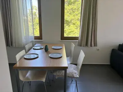 a dining room table with white chairs and a wooden table at Sozopol Paradise view in Sozopol