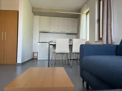 a living room with a couch and a table and a kitchen at Sozopol Paradise view in Sozopol