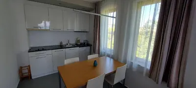 a kitchen with a wooden table and white cabinets at Sozopol Paradise view in Sozopol