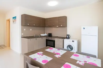 a kitchen with a table with pink decorations on it at Star Dreams Apartment with Glass Veranda in Sveti Vlas