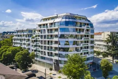 a tall building with a lot of windows at HOT Main Square Newly Built Modern Apartment in Burgas City