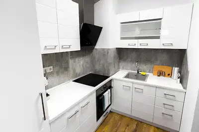 a white kitchen with white cabinets and a sink at HOT Main Square Newly Built Modern Apartment in Burgas City