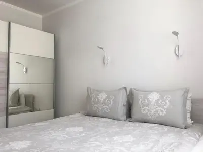a bedroom with a bed with two pillows and a mirror at HOT Main Square Newly Built Modern Apartment in Burgas City