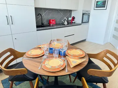 a wooden table with plates and glasses on it in a kitchen at Luxus living in Burgas in Burgas City