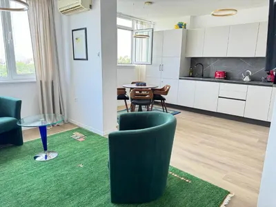 a living room with a green chair and a table at Luxus living in Burgas in Burgas City