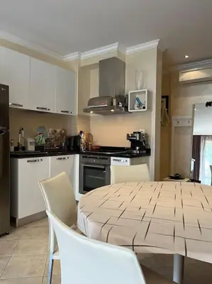 a kitchen with a table and chairs in a kitchen at 2 Apartment Verano Del Mar Sozopol in Sozopol