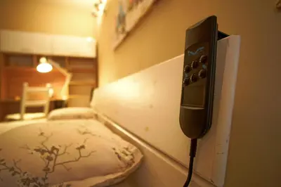 a phone hanging on a wall next to a bed at Super Cozy Central Apartment in the Heart of Varna in Varna City