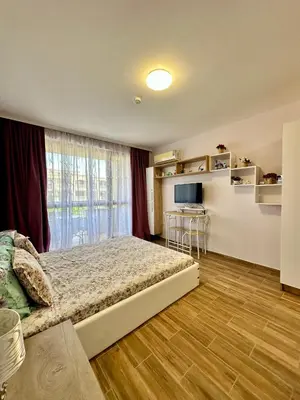 a bedroom with a bed and a large window at Studio at Kaskadas A44 in Sunny Beach