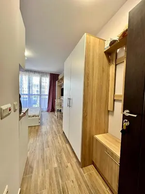 a kitchen with a white refrigerator and wooden floors at Studio at Kaskadas A44 in Sunny Beach