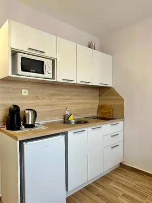 a white kitchen with a sink and a microwave at Studio at Kaskadas A44 in Sunny Beach